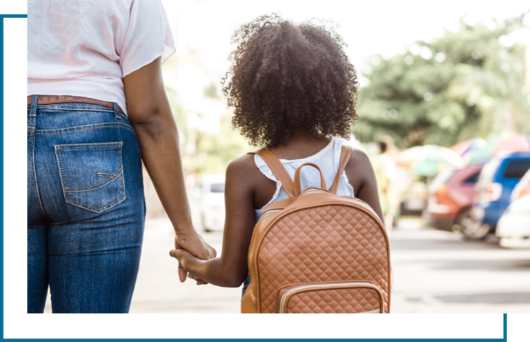 Mother holding daughter's hand as she waits to be picked up by her father.