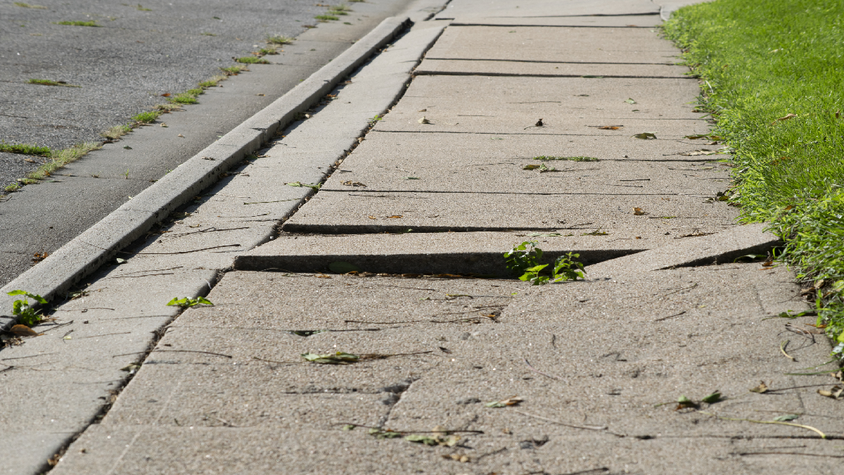 An uneven sidewalk next to road
