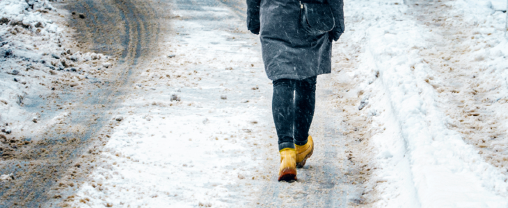 Ice on sidewalk as woman is walking