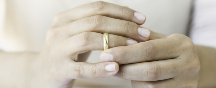 Woman holding her wedding band, emphasizing the potential for divorce