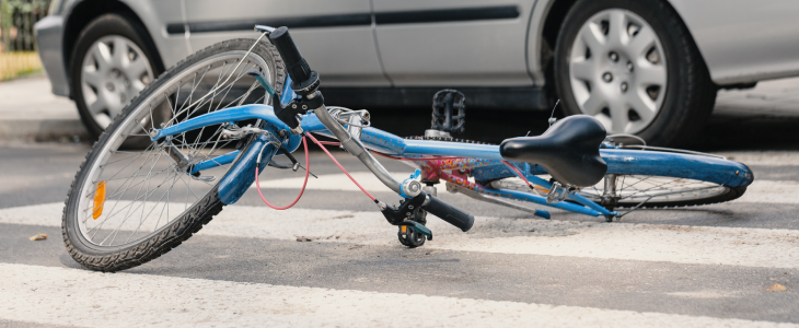 Bicycle flipped over on the middle of a crosswalk, representing a bicycle collision with a car.